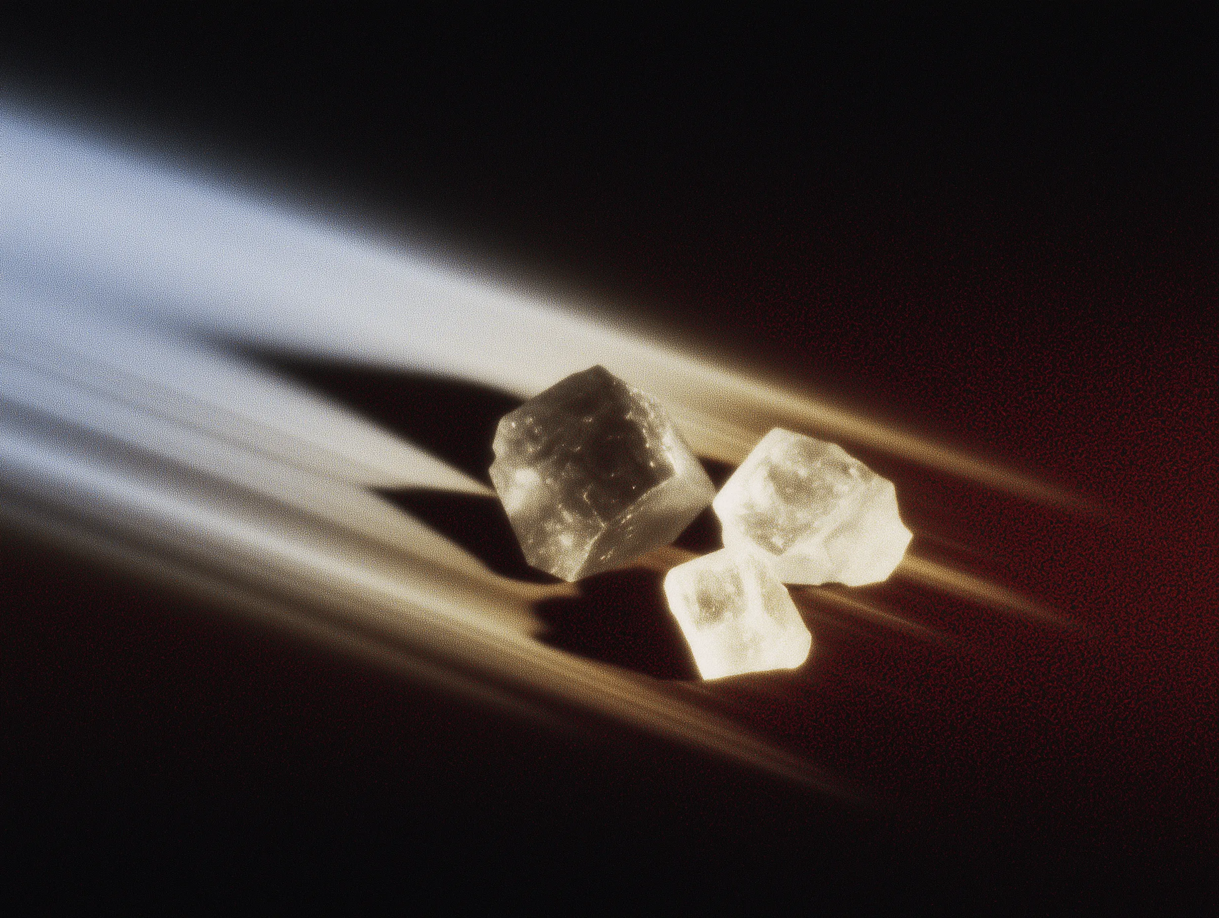 Cubos de hielo iluminados sobre fondo oscuro.